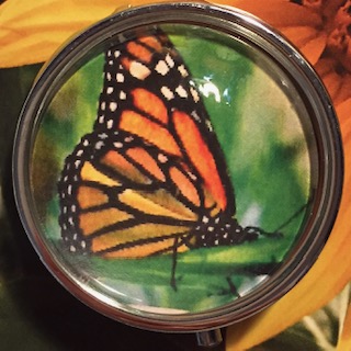 Custom embroidered large cabochon pillbox with orange butterfly on it